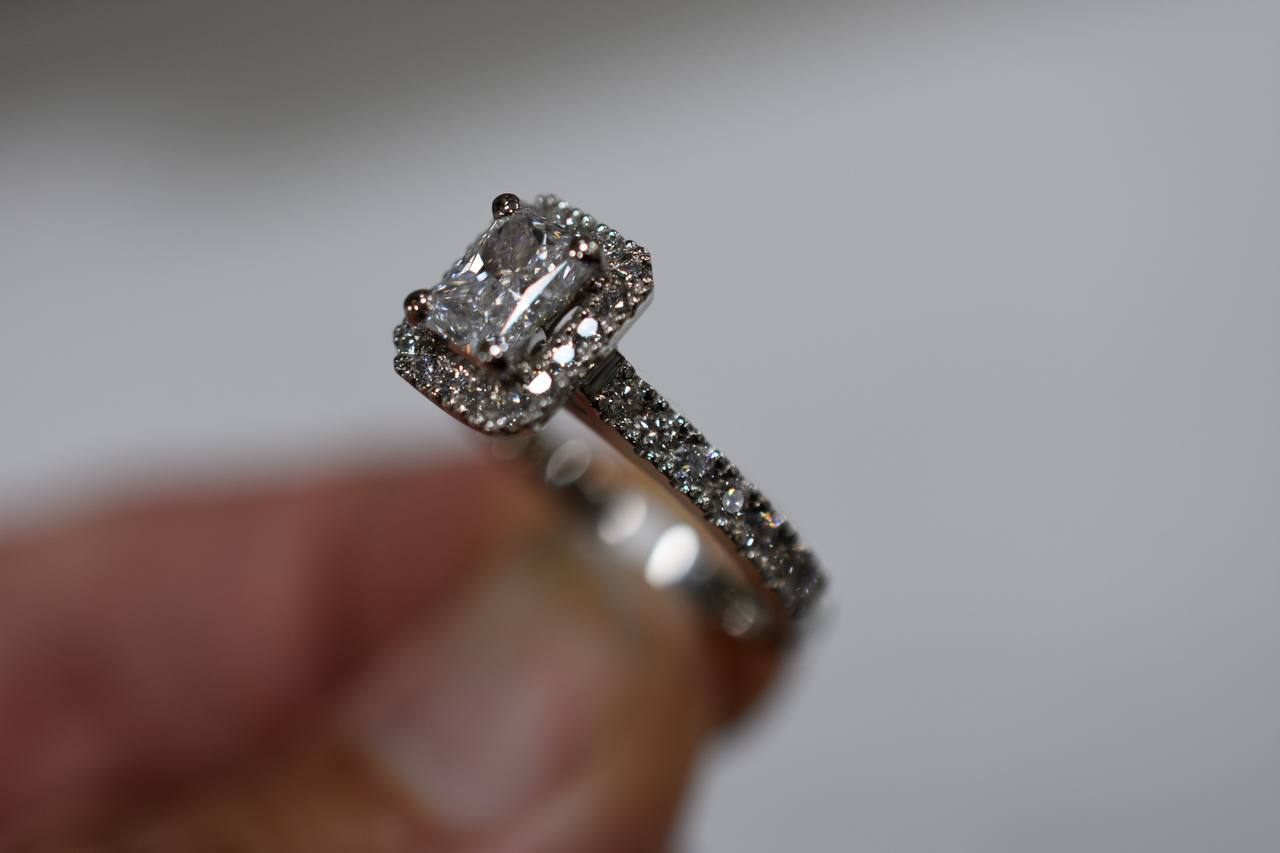 Platinum, diamond set engagament ring with halo of diamonds & diamonds on shoulders. TDW 1.18ct